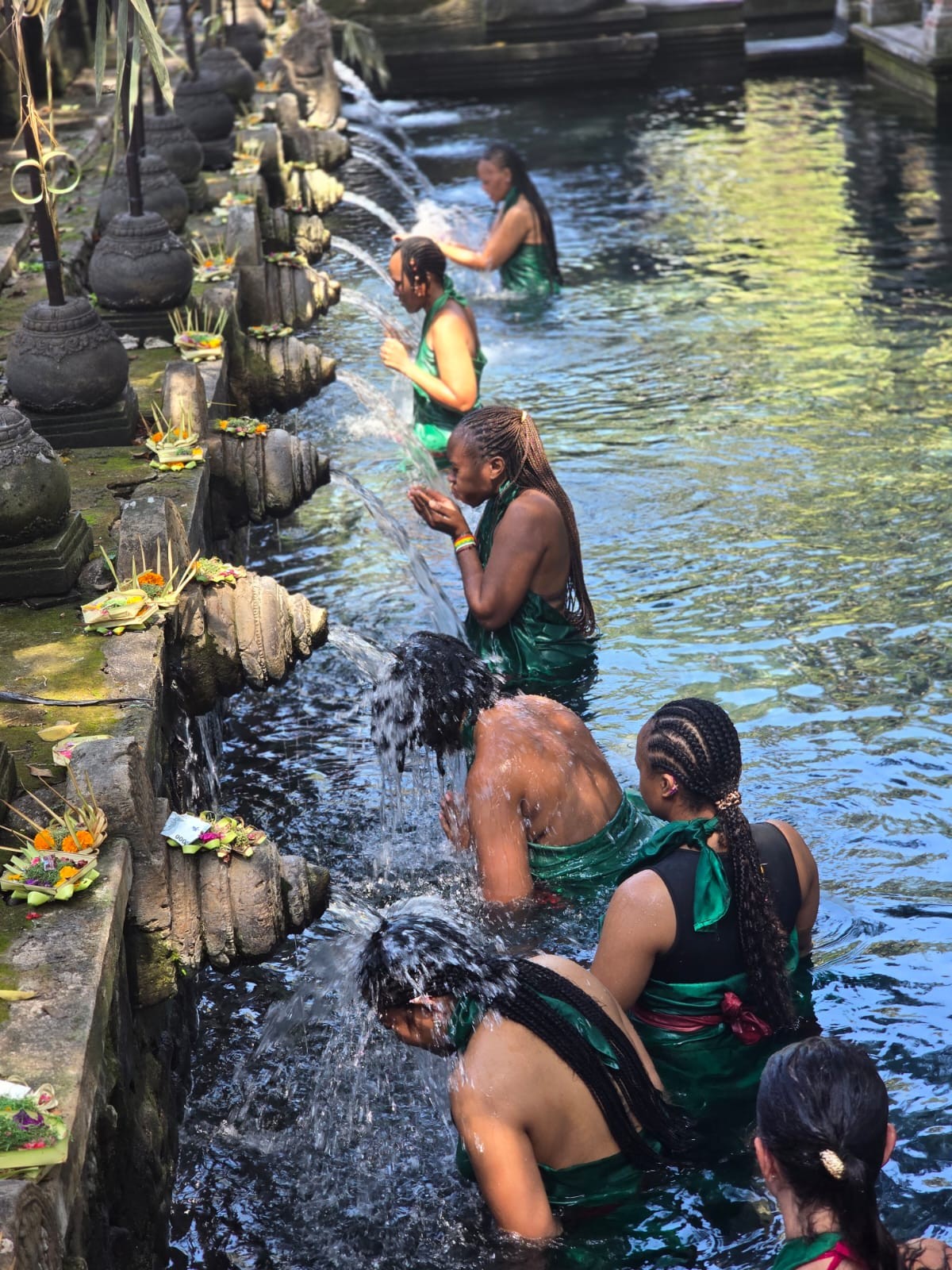 Travellers participating in a water cleansing experience